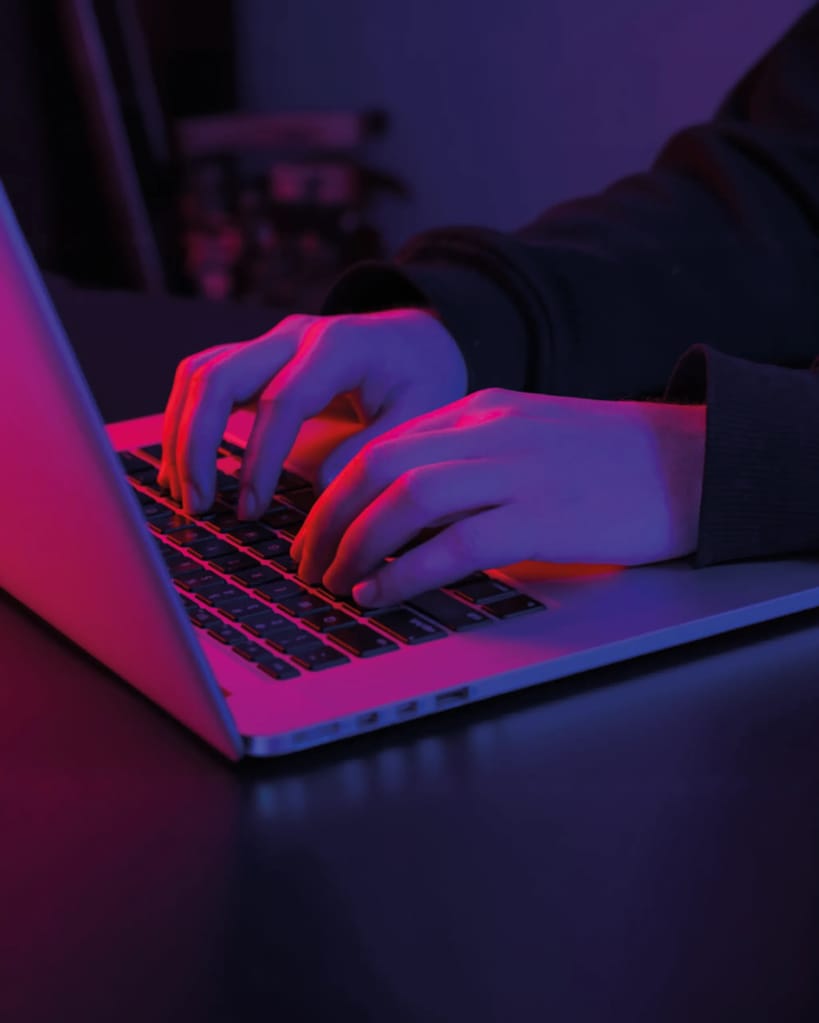 Hands on Laptop with dark pink light